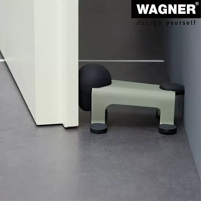 Wagner System Bodentürstopper EH5207 - L x B x H: 59 x 106 x 71 mm, Stahl, Grau - Salbeigrüner Türstopper aus Metall mit schwarzen Gummielementen, an einem weißen Türrahmen positioniert.
