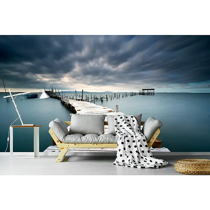 Papermoon Premium collection Fototapete Letzter Pfad - B x H: 250 x 186 cm, Vlies - Wandbild mit einer malerischen Seebrücke, das eine entspannende Atmosphäre in jeden Raum bringt. Sofa, Lampe und Hocker ergänzen das Ambiente.
