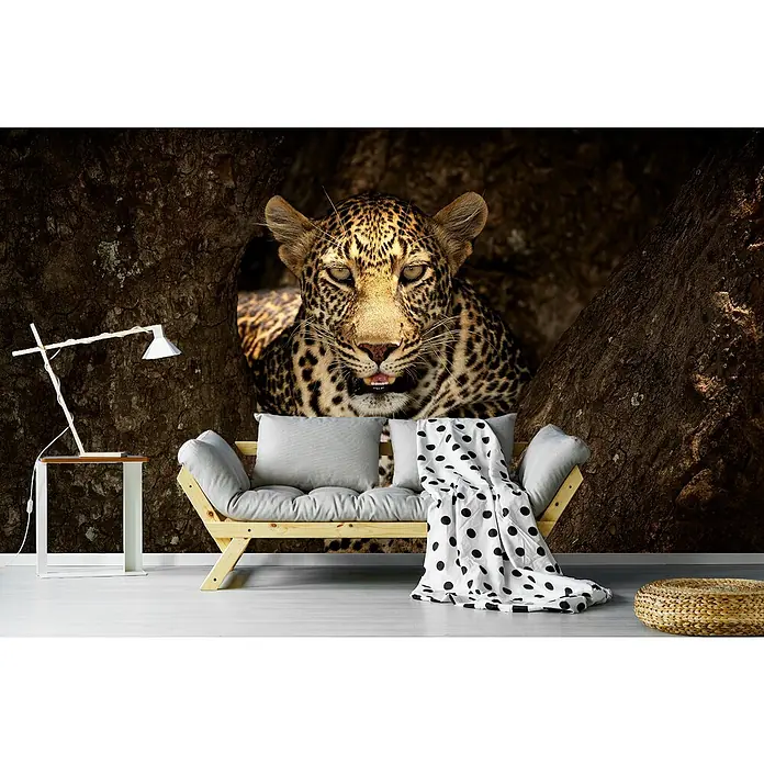 Papermoon Premium collection Fototapete Leopard Masai Mara - B x H: 450 x 280 cm, Vlies - Ein Wandbild mit einem Leoparden, der aus einer Höhle schaut, über einem stilvollen Sofa mit Polka-Dot-Decke und einer modernen Lampe.