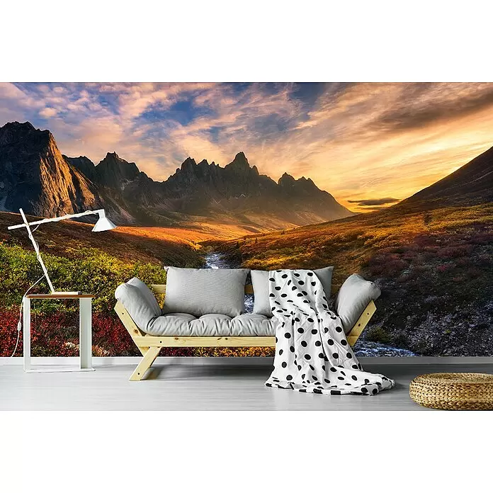 Papermoon Premium collection Fototapete Bergparadies - B x H: 450 x 280 cm, Vlies - Gemütliches Wohnzimmer mit hellem Holz-Futonsofa, weißem Beistelltisch, moderner weißer Lampe und einem geflochtenen Pouf vor einem Bergpanorama.