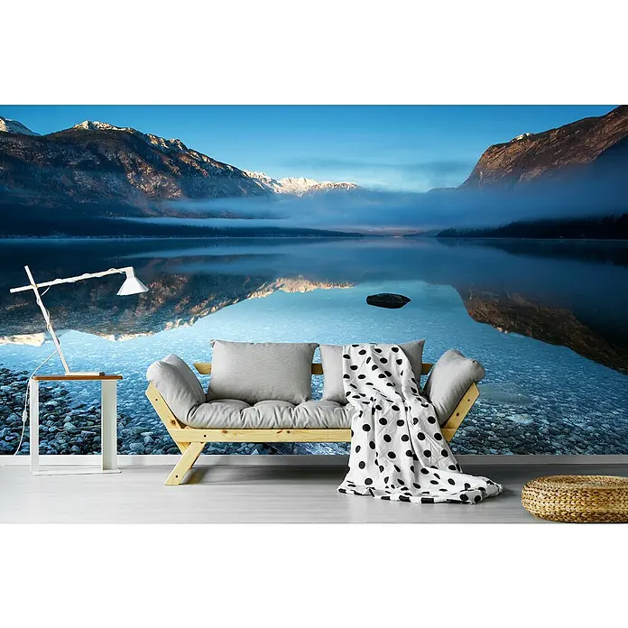 Papermoon Premium collection Fototapete Bohinjs Ruhigkeit - B x H: 350 x 260 cm, Vlies - Gemütliches Interieur mit einem Sofa, einer Lampe und einem Hocker vor einer ruhigen Bergsee-Tapete für eine entspannende Raumatmosphäre.