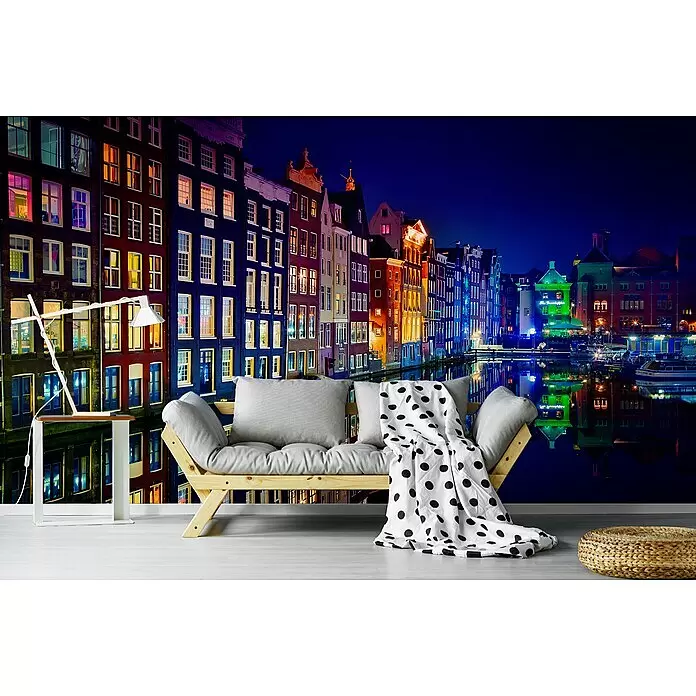 Papermoon Premium collection Fototapete Amsterdam - B x H: 250 x 186 cm, Vlies - Lebhaftes Wandbild von bunten Kanalhäusern einer Nachtstadt mit Wasserreflexionen, als Kulisse für Sofa und Tisch.