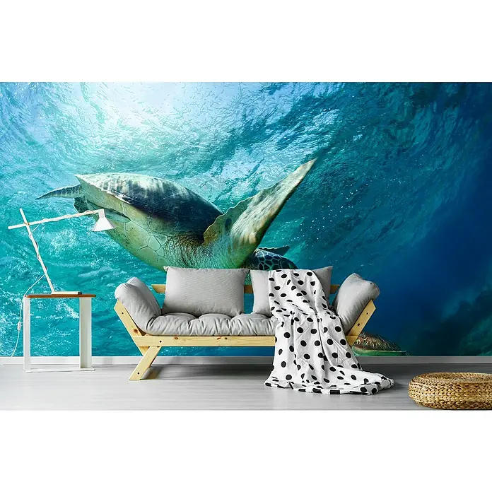 Papermoon Premium collection Fototapete Schildkröten unter Wasser - B x H: 250 x 186 cm, Vlies - Modernes Wohnzimmer mit einer Couch mit grauen Kissen und einer Tagesdecke mit schwarzen Punkten vor einer Wandtapete mit Schildkrötenmotiv.