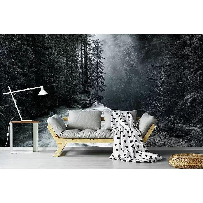 Papermoon Premium collection Fototapete Über den Fällen - B x H: 200 x 149 cm, Vlies - Ein gemütlicher Wohnbereich mit hellem Holzsofa, grauen Kissen und gepunkteter Decke, neben weißem Tisch mit Lampe, vor Waldwandbild.