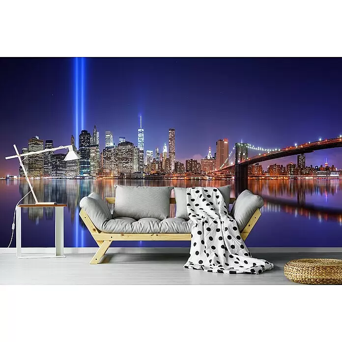 Papermoon Premium collection Fototapete In Gedenken - B x H: 350 x 260 cm, Vlies - Hellgraues Sofa mit gepunkteter Decke, Holztisch mit Lampe und geflochtenem Pouf in einem Zimmer mit New Yorker Skyline Wandbild.