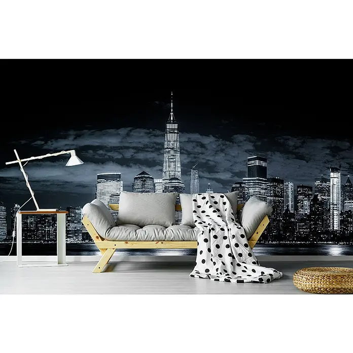 Papermoon Premium collection Fototapete Gotham - B x H: 200 x 149 cm, Vlies - Ein gemütliches Wohnzimmer mit einem stilvollen Sofa, einer Lampe und einem Hocker vor einer beeindruckenden Skyline-Tapete.