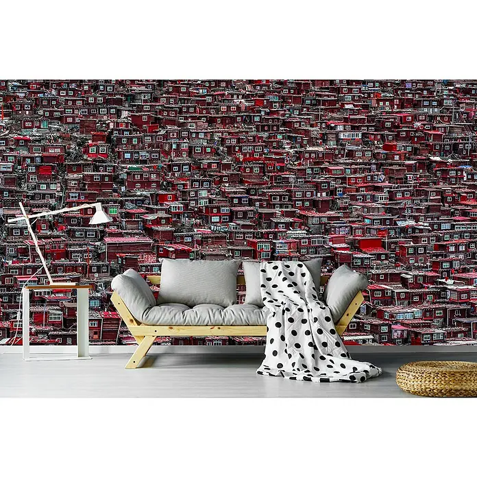 Papermoon Premium collection Fototapete Rote Häuser - B x H: 250 x 186 cm, Vlies - Wohnzimmer-Szene mit einem modernen Sofa, einer Stehlampe und einem Hocker vor einer Tapete mit Hausmuster.