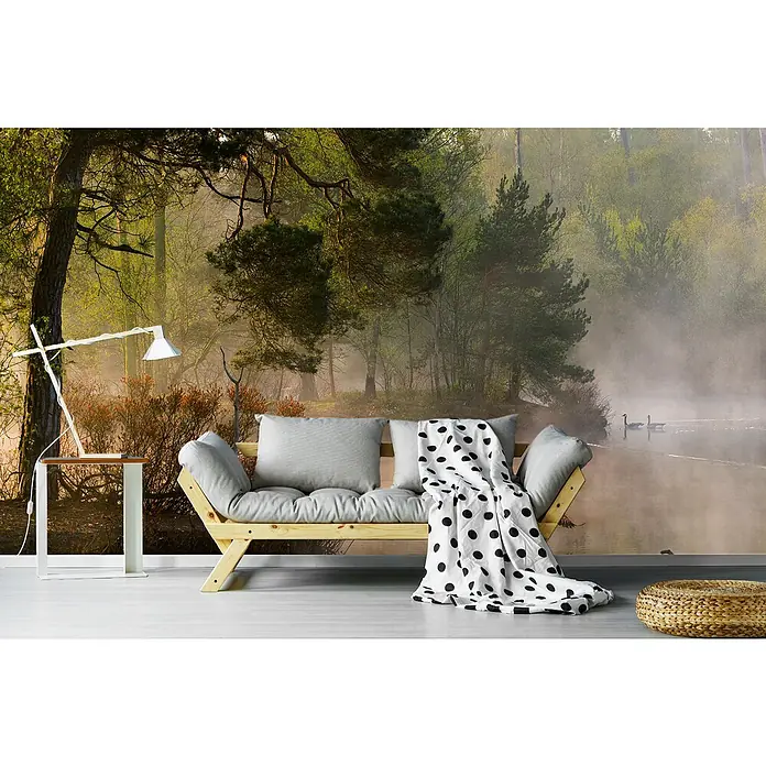Papermoon Premium collection Fototapete Gänsehaut - B x H: 250 x 186 cm, Vlies - Wohnzimmer mit hellgrauem Sofa, Holzrahmen, Tischlampe und einem Hocker vor einer Waldtapete mit See und Schwänen.