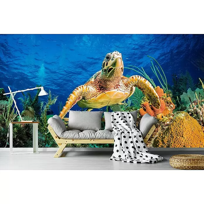 Papermoon Premium collection Fototapete Turtle Karibik Riff - B x H: 250 x 186 cm, Vlies - Helles Holzsofa mit grauen Kissen und einer gepunkteten Decke in einem Raum mit Unterwassermural.