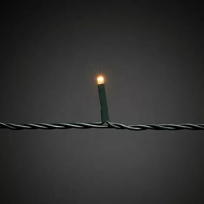 Konstsmide LED-Lichterkette Baummantel - Innen, Lichtfarbe: Bernstein, Anzahl Leuchtmittel: 250 Stk., Netzbetrieben - Beleuchtetes warmweißes LED-Licht an einem dunkelgrünen verdrillten Kabel.