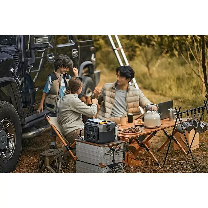 EcoFlow Estación de energía portátil River 2 Max - 512 Wh, Negro - Estación de energía Ecoflow gris y negra cargando dispositivos en una mesa de camping durante una salida familiar con SUV.