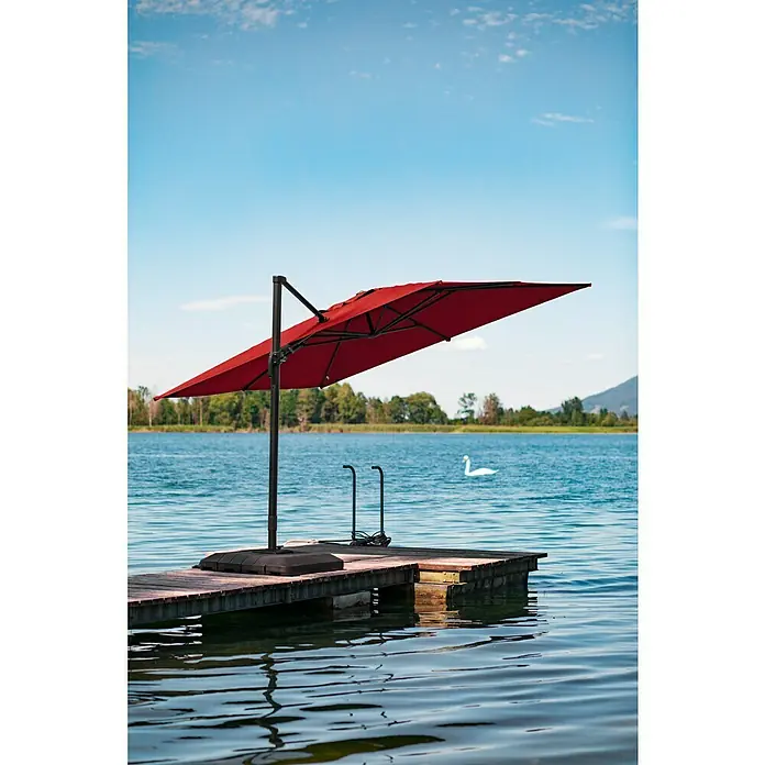 Sunfun Ampelschirm Capri - Rot, Bespannungsmaß (L x B): 300 x 350 cm - Roter Ampelschirm auf einem Holzsteg am See, der Schatten spendet. Ein Schwan schwimmt friedlich im Hintergrund.