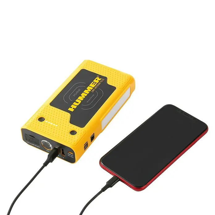 Kit de arranque HUMMH3T - 12 V, 3 Ah - 8 Ah - Paquete de batería amarilla Hummer cargando un teléfono inteligente rojo con un cable negro. Un cargador práctico para llevar.