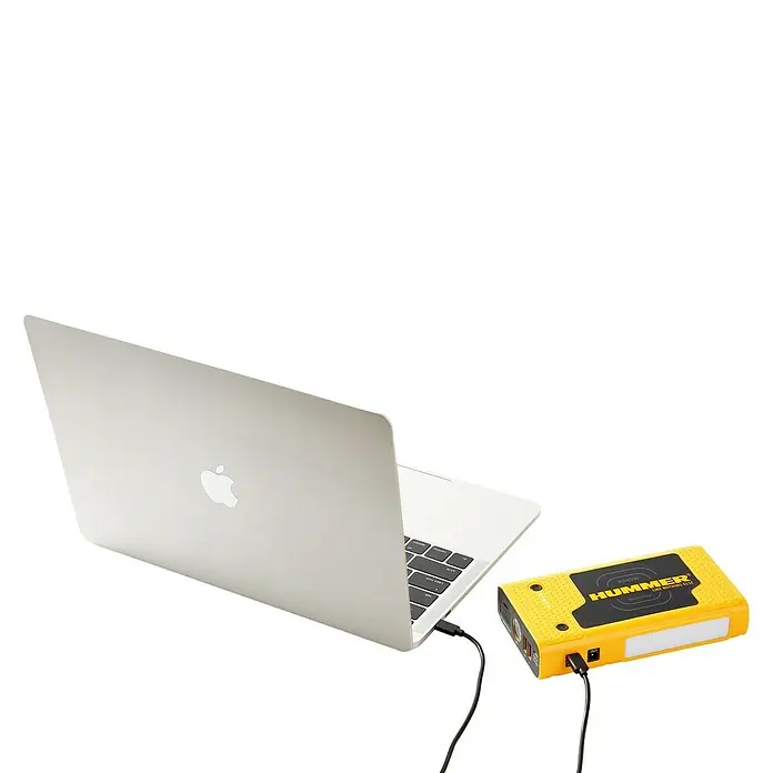 Kit de arranque HUMMH3T - 12 V, 3 Ah - 8 Ah - Un portátil plateado conectado a un paquete de energía Hummer amarillo que emite luz, para la fuente de alimentación.