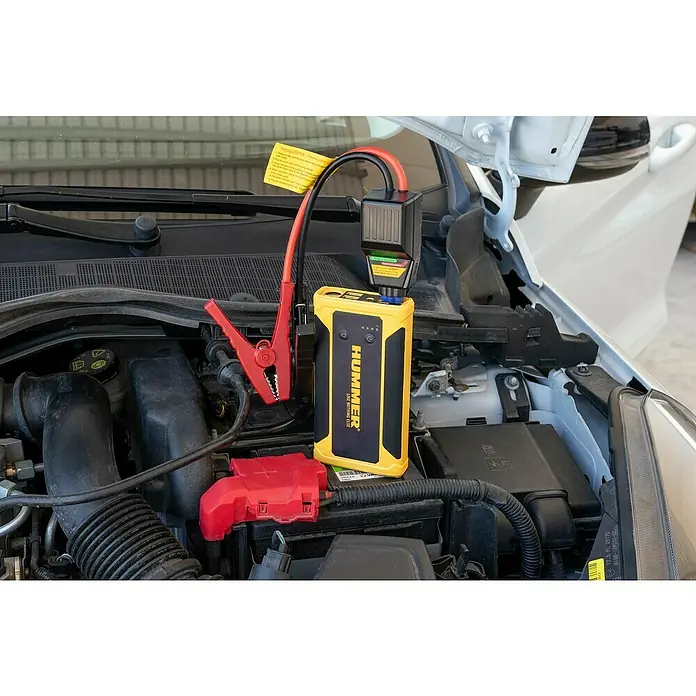 Kit de arranque HUMMHX - 12 V, 3 Ah - Un arrancador de batería amarillo Hummer conectado a un coche. Incluye una pinza de cocodrilo roja.