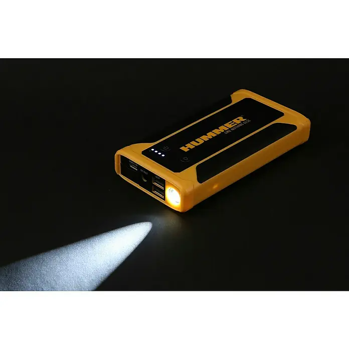 Kit de arranque HUMMHX - 12 V, 3 Ah - Primer plano de un arrancador de batería amarillo HUMMER con linterna encendida, sobre un fondo negro.