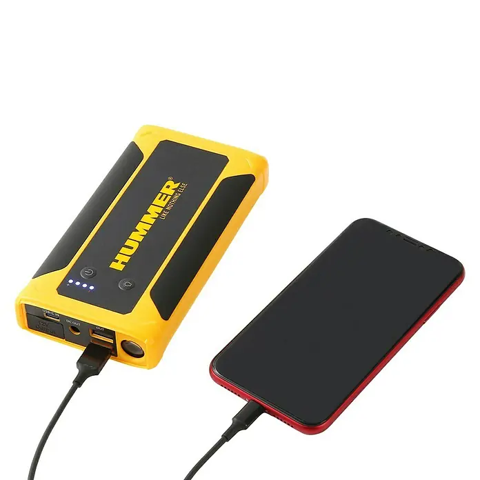 Kit de arranque HUMMHX - 12 V, 3 Ah - Amplificador de arranque Hummer amarillo cargando un teléfono inteligente rojo con un cable USB.