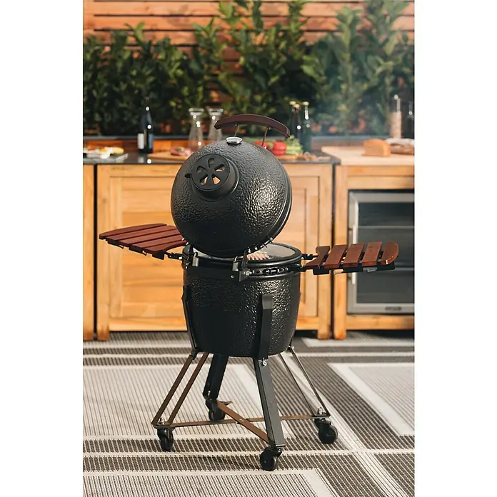Kingstone Holzkohlegrill Kamado 38 - Durchmesser Grillfläche: 38,3 cm, Schwarz - Hier ist ein Kugelgrill mit Seitentischen vor einem Holzküchenschrank. Das Design bietet Komfort und Stil beim Grillen im Freien.