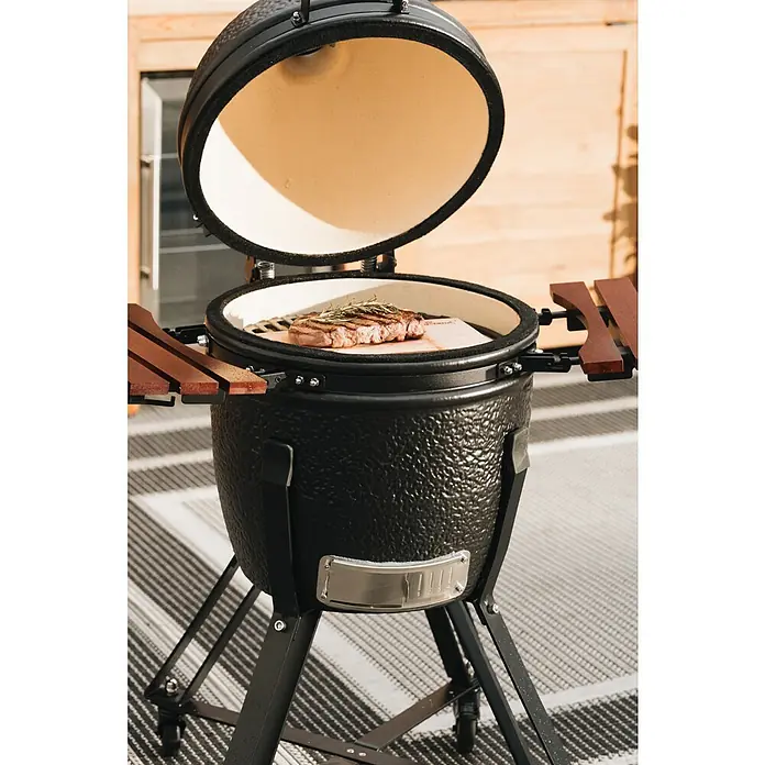 Kingstone Räucherplanken - L x B: 24 x 41 cm - Nahaufnahme eines schwarzen Keramikgrills mit einem Steak darin, bereit zum Servieren.