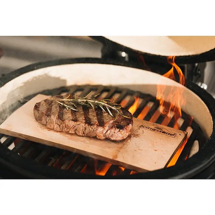 Kingstone Räucherplanken - L x B: 24 x 41 cm - Ein saftiges Steak auf einer Zedernholzplanke mit Rosmarin, zubereitet auf einem Grill, das für köstlichen Geschmack sorgt.
