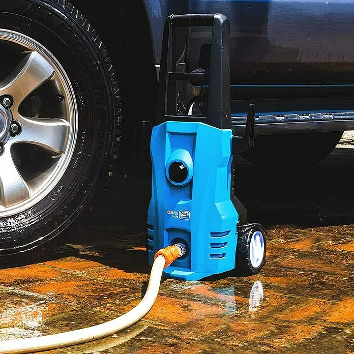 Koma Tools PRO Series Hidrolimpiadora de alta presión - 120 bar, 1.400 W, Capacidad de bombeo: 432 l/h - Primer plano de una hidrolimpiadora azul Koma Pro conectada a un coche, centrado en sus características.