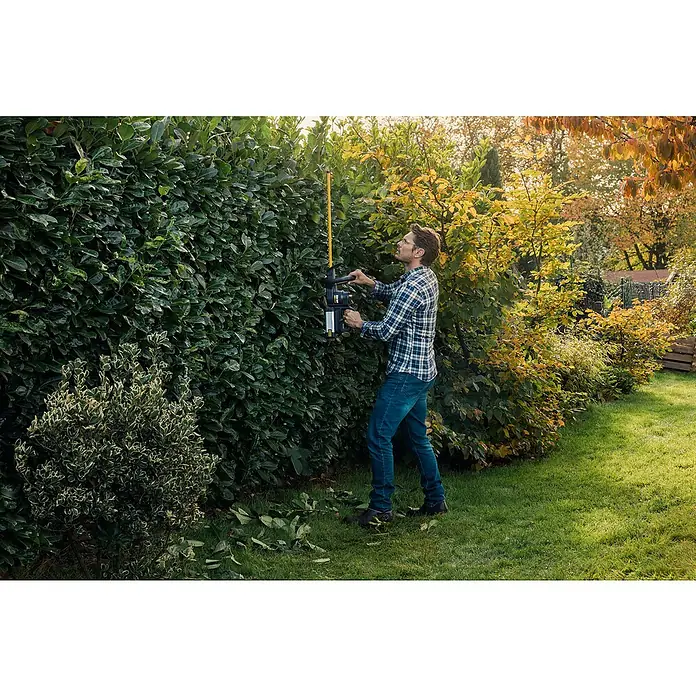 Worx ENVIRO Akku-Heckenschere EG261.9 - 60 V, 2 Ah, 1 Akku - Ein Mann trimmt eine Hecke mit einer Kärcher Akku-Teleskop-Heckenschere, um seinen Garten zu pflegen.