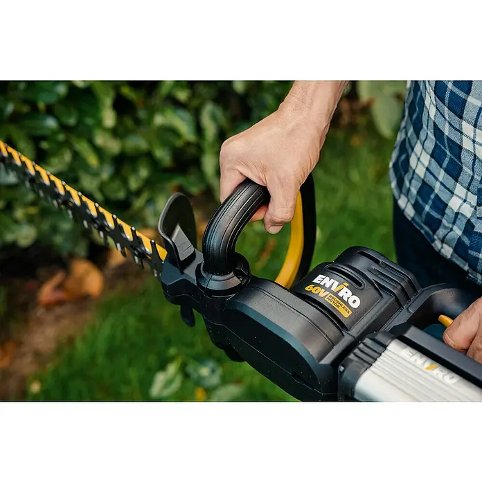 Worx ENVIRO Akku-Heckenschere EG261.9 - 60 V, 2 Ah, 1 Akku - Nahaufnahme einer ENVRO 60V Akku-Heckenschere in Aktion, gehalten von einer Person im Garten.