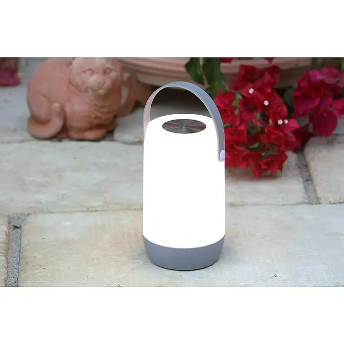 Mobiles Licht Sona Touch - Weiß, Höhe: 19 cm, IP44 - Tragbare LED-Laterne mit grauem Griff und weißem Licht auf einem Steintisch, ideal für Gartenpartys und stimmungsvolle Beleuchtung.