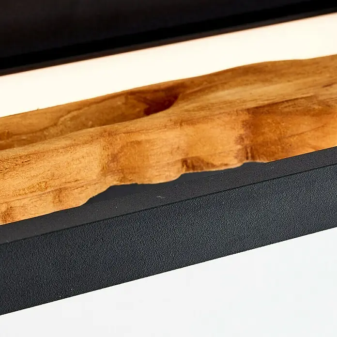 Brilliant LED-Wandleuchte Chaumont - 9,5 W, L x B x H: 10 x 35 x 15,1 cm, Schwarz, Warmweiß - Nahaufnahme eines Holzes in einer eleganten schwarzen Halterung, das Design und natürliche Ästhetik vereint.
