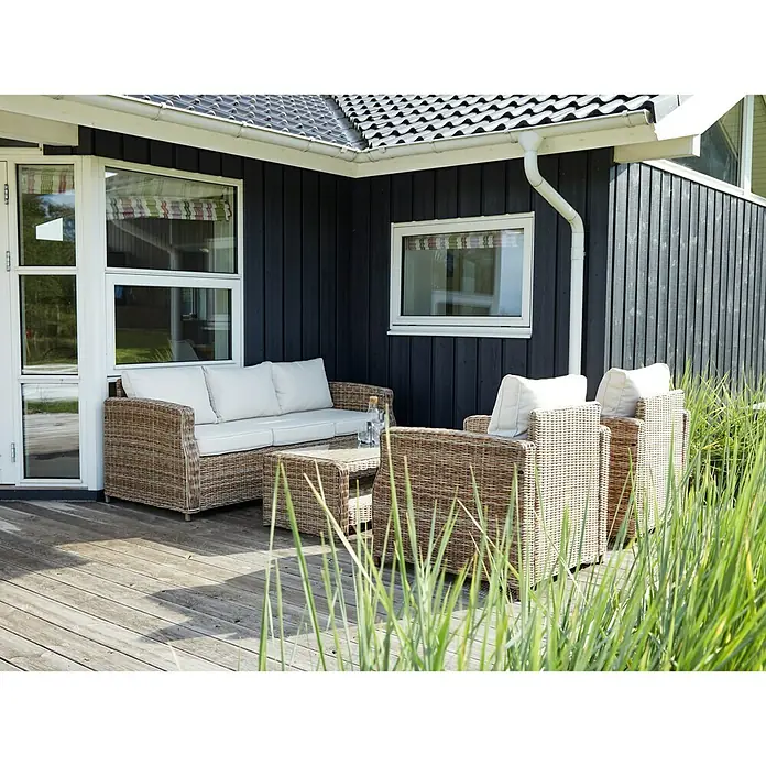 Sillón de exterior Gotland - An x Pr x Al: 80 x 81 x 77 cm, Aluminio/Ratán sintético, Beige - Acogedor conjunto de muebles de jardín de ratán en una terraza de madera frente a una casa moderna. Ideal para la relajación al aire libre.