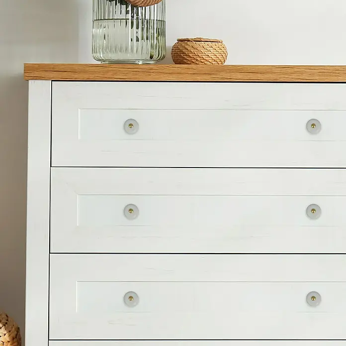 Häfele Pomo para muebles - Tipo de tirador del mueble: Botón, Porcelana, Ø x L: 25 x 29 mm - Cómoda de madera blanca con seis cajones y pomos redondos, sobre la que hay un jarrón de vidrio y una cesta de mimbre.