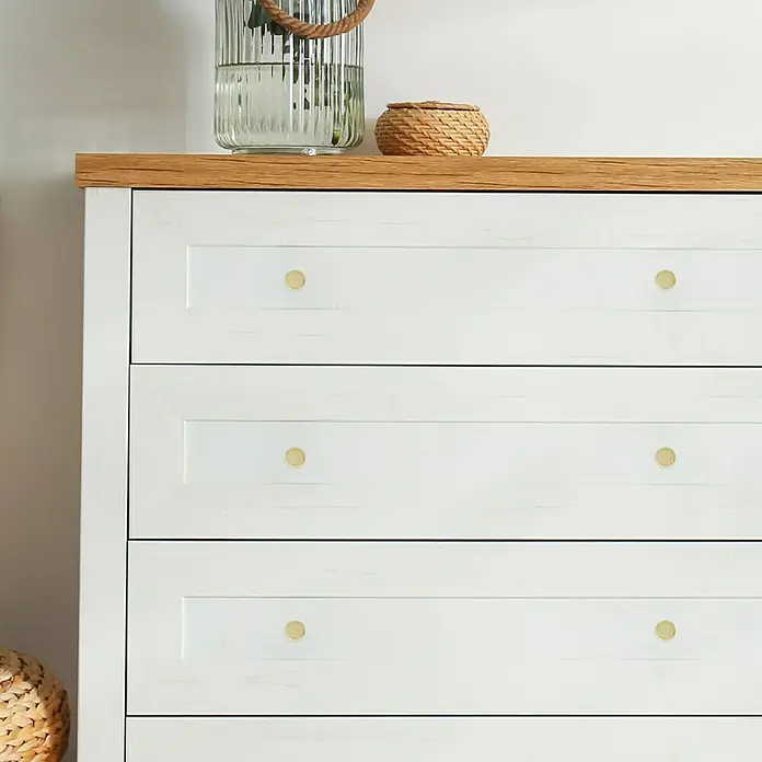 Häfele Pomo para muebles - Tipo de tirador del mueble: Botón, Ø x Al: 30 x 22 mm - Primer plano de una cómoda blanca con tiradores dorados, que muestra un mueble elegante y con estilo. Elementos decorativos colocados encima.