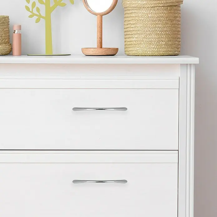 Häfele Tirador para muebles - L x An x Al: 158 x 11 x 29 mm, Tipo de tirador del mueble: Estribo, Distancia entre orificios: 128 mm, Otros, Cromado, Brillante - Primer plano de una cómoda blanca con dos cajones y tiradores plateados. Mueble sencillo y elegante para espacios de vida modernos.