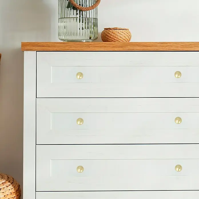 Häfele Pomo para muebles - Tipo de tirador del mueble: Botón, Ø x Al: 25 x 35 mm, Resplandeciente, Dorado - Primer plano de una cómoda blanca con pomos dorados, añadiendo un toque de elegancia y estilo a cualquier dormitorio.