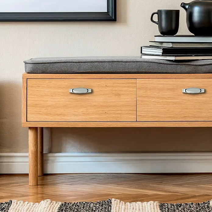 Häfele Tirador para muebles - Tipo de tirador del mueble: Estribo, Aluminio, Cromado, Ø x L: 71 x 22 mm - Primer plano de un mueble de madera con dos cajones y tiradores ovalados plateados, mostrando su diseño elegante y funcional.