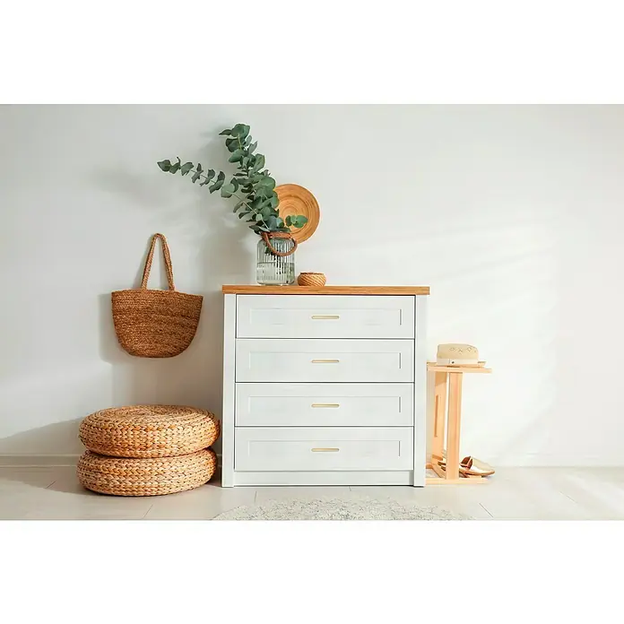 MöbelgriffTyp Möbelgriff: Bügel, Holz, Lackiert, B x L: 30 x 100 mm, Fichte - Elegante Kommode mit vier Schubladen und Holzplatte, dekoriert mit Accessoires wie Tasche, Pflanzen und Hut.