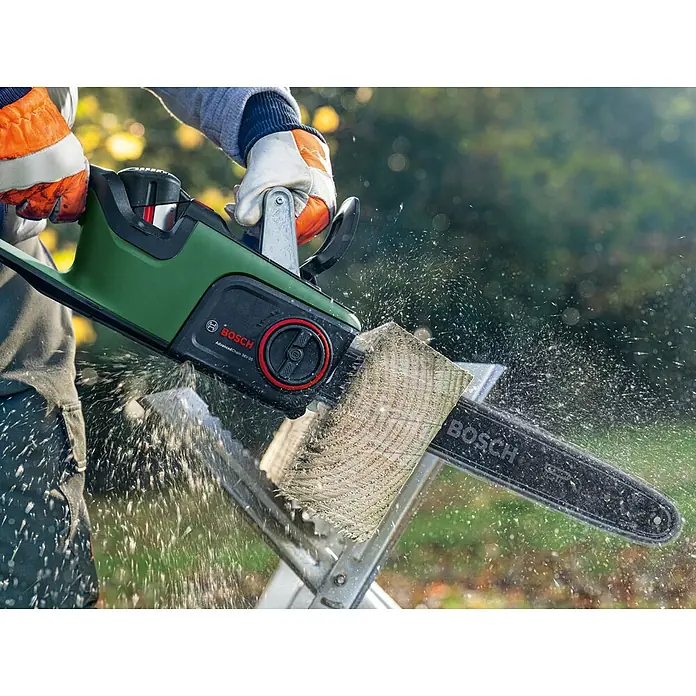 Bosch Power for All 36V Akku-Kettensäge AdvancedChain 36V-35-40 - 36 V, Li-Ionen, Ohne Akku, Schwertlänge: 35 cm - Eine Bosch AdvancedChain 36V-35 Kettensäge in Aktion, die durch ein Holzstück schneidet und Sägespäne versprüht.