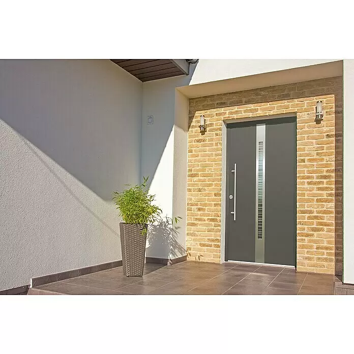 Splendoor Haustür Thermodoor PLUS SP20 - 110 x 210 cm, DIN Anschlag: Links, Anthrazitgrau Feinstruktur - Moderne graue Haustür mit vertikalem Milchglaseinsatz und langem silbernem Griff, in einem Hauseingang aus Ziegeln.