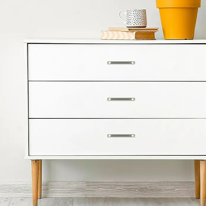 Häfele Möbelgriff - Typ Möbelgriff: Bügel, L x B x H: 102 x 12 x 30 mm, Lochabstand: 96 mm - Weiße Kommode mit drei Schubladen und silberfarbenen Griffen, ideal für die Aufbewahrung im Schlafzimmer oder Wohnzimmer.