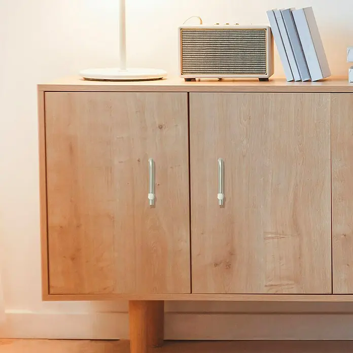 Häfele Tirador para muebles - Tipo de tirador del mueble: Barra, Distancia entre orificios: 64 mm - Primer plano de un mueble de madera con modernos tiradores plateados, perfecto para un almacenamiento elegante en cualquier espacio.