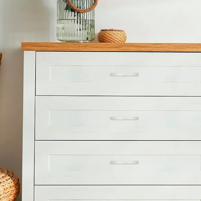 Häfele Tirador para muebles - L x An x Al: 151 x 16 x 34 mm, Aluminio, Distancia entre orificios: 128 mm - Primer plano de una cómoda blanca con tapa de madera y elementos decorativos.