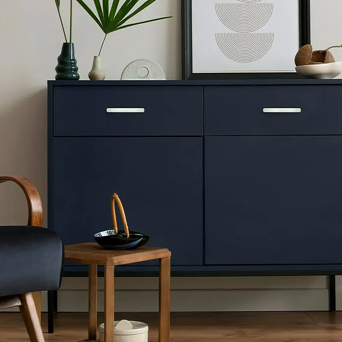 Häfele Tirador para muebles - L x An x Al: 151 x 16 x 34 mm, Aluminio, Distancia entre orificios: 128 mm - Elegante aparador azul marino con tiradores plateados, adornado con plantas y arte minimalista, perfecto para soluciones de almacenamiento con estilo.