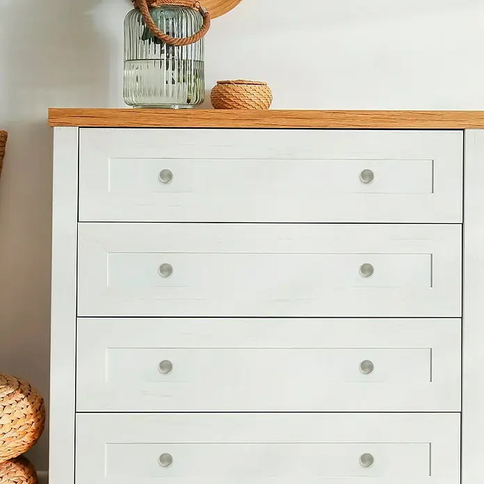 Häfele Pomo para muebles - Tipo de tirador del mueble: Botón, Diámetro: 25 mm - Cómoda de madera clara y cajones blancos con pomos plateados y un tarro de cristal decorativo encima.
