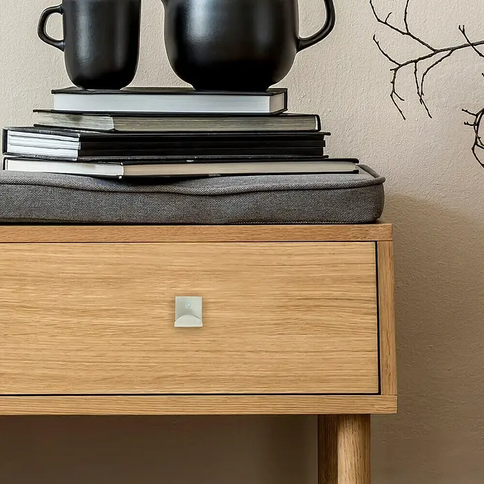 Häfele Tirador para muebles - L x An x Al: 45 x 28 x 32 mm - Primer plano de un armario de madera con un tirador metálico cuadrado, que ofrece una estética moderna y elegante.