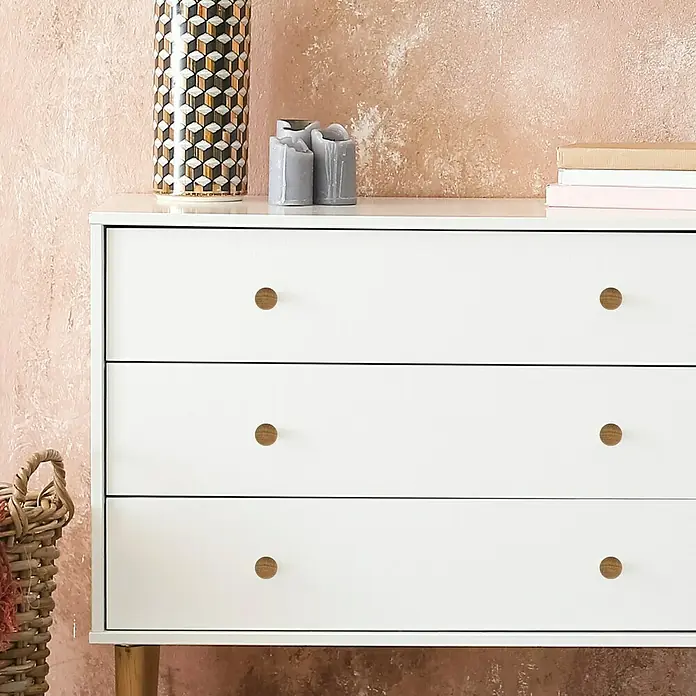Häfele Pomo para muebles - Tipo de tirador del mueble: Botón, Ø x Al: 37 x 25 mm, Lacado - Primer plano de una cómoda blanca con tres cajones y pomos de madera, decorada con velas y un jarrón.