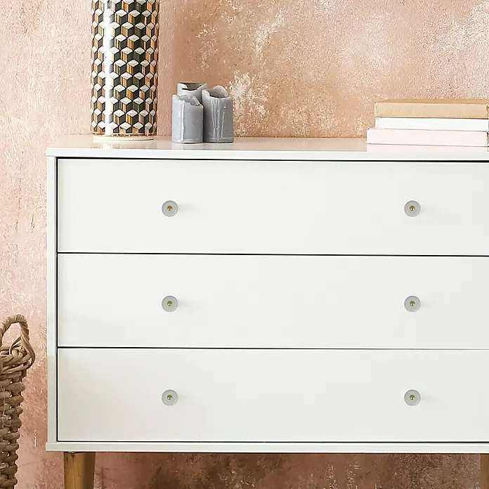 MöbelknopfTyp Möbelgriff: Knopf, Porzellan, Ø x L: 32 x 29 mm - Weißer Schrank mit drei Schubladen und runden Knöpfen, neben dekorativen Gegenständen auf einem Tisch. Praktisch und stilvoll.