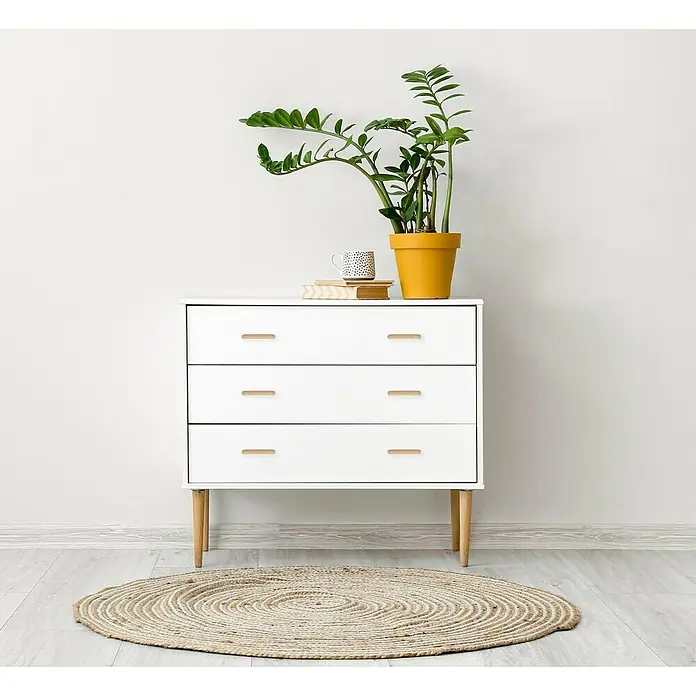Häfele Tirador para muebles - Madera, Lacado, An x L: 30 x 100 mm, Haya - Cómoda blanca de tres cajones con una planta y una taza encima, ideal para cualquier espacio.