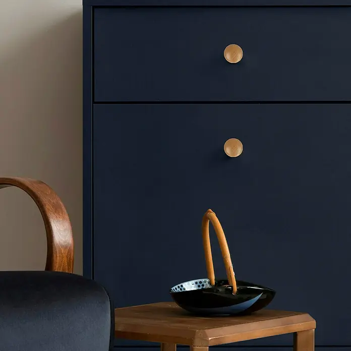 Häfele Pomo para muebles - Ø x Al: 40 x 25 mm, Madera, Lacado - Primer plano de un armario azul con tiradores de madera y una cesta decorativa sobre una pequeña mesa de madera.