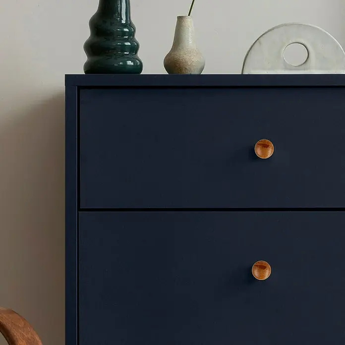 Häfele Pomo para muebles - Madera, Lacado, Diámetro: 30 mm - Primer plano de una cómoda azul oscuro con tiradores de madera y objetos decorativos encima.