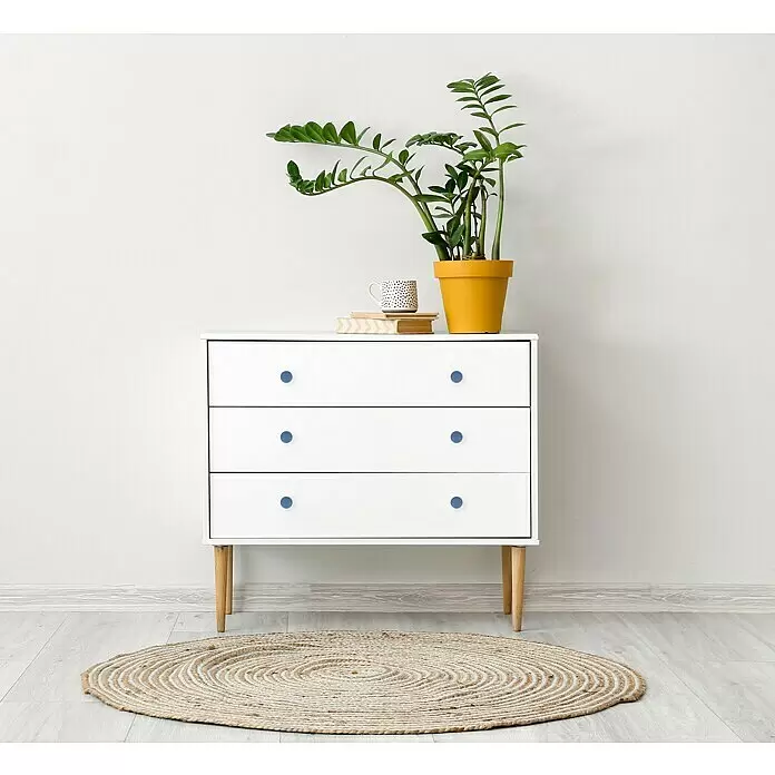Häfele Pomo para muebles - Tipo de tirador del mueble: Botón, Ø x Al: 52 x 24 mm, Plástico, Azul - Cómoda blanca de tres cajones con pomos azules, con una planta y libros encima, y una alfombra redonda de yute.